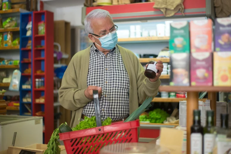 older man shopping at the grocery store with a mask